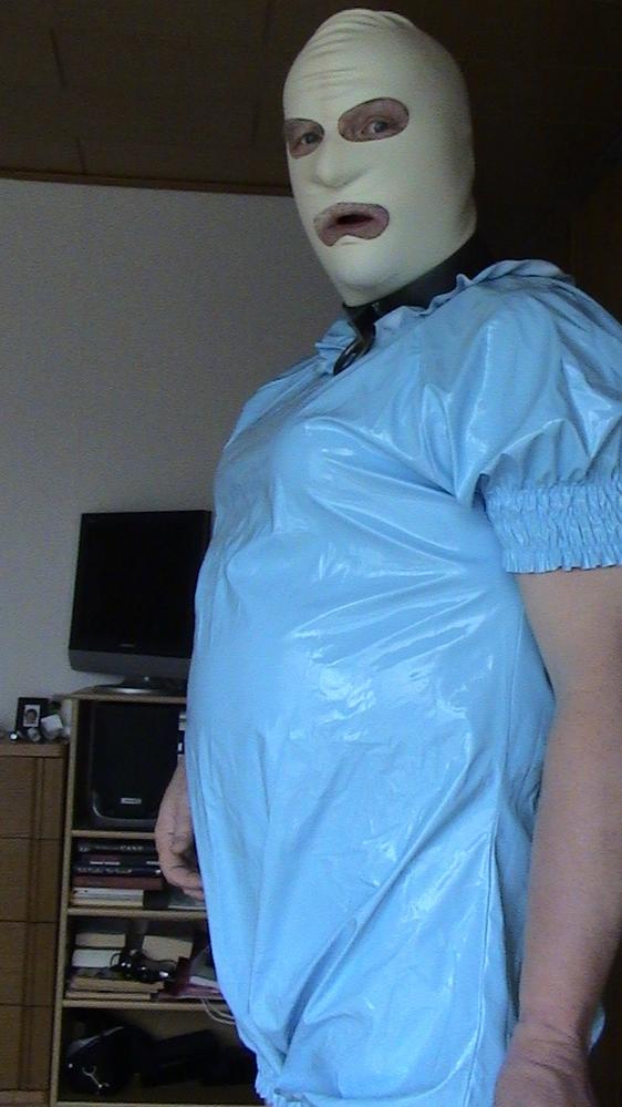 Babyslave mit Plastikspielanzug, Latexmaske und Halseisen
